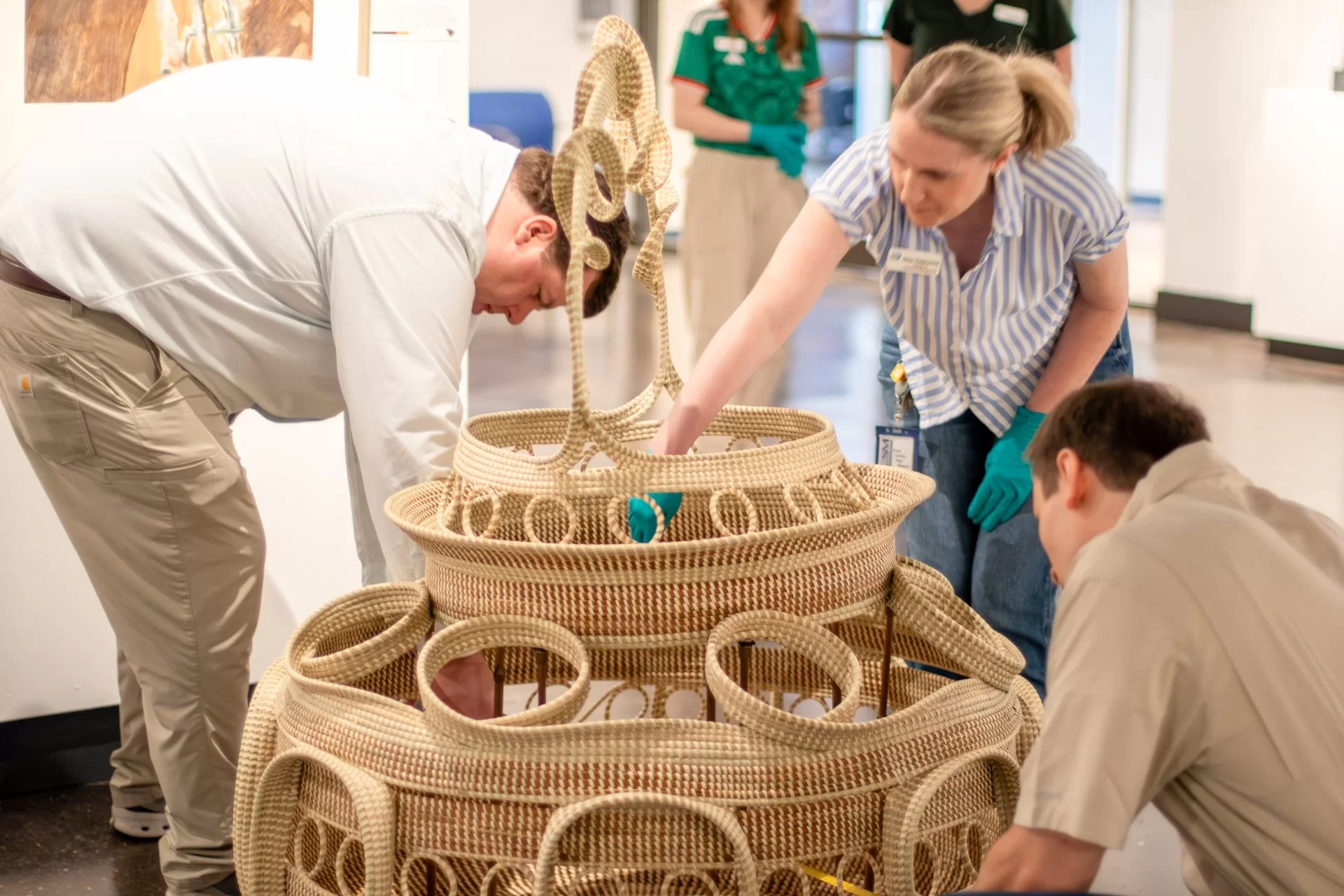 Personal del South Carolina State Museum mide Big Percy, la canasta de sweetgrass creada por Corey Alston.