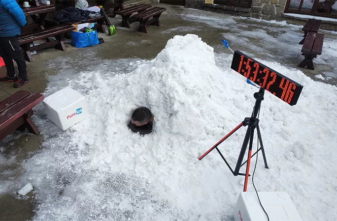 Damian Kasprzyk enterrado en una montaña de nieve junto a un cronómetro