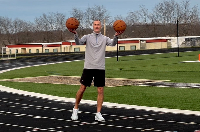 Michael Dodd listo para intentar el récord de una milla botando dos balones.