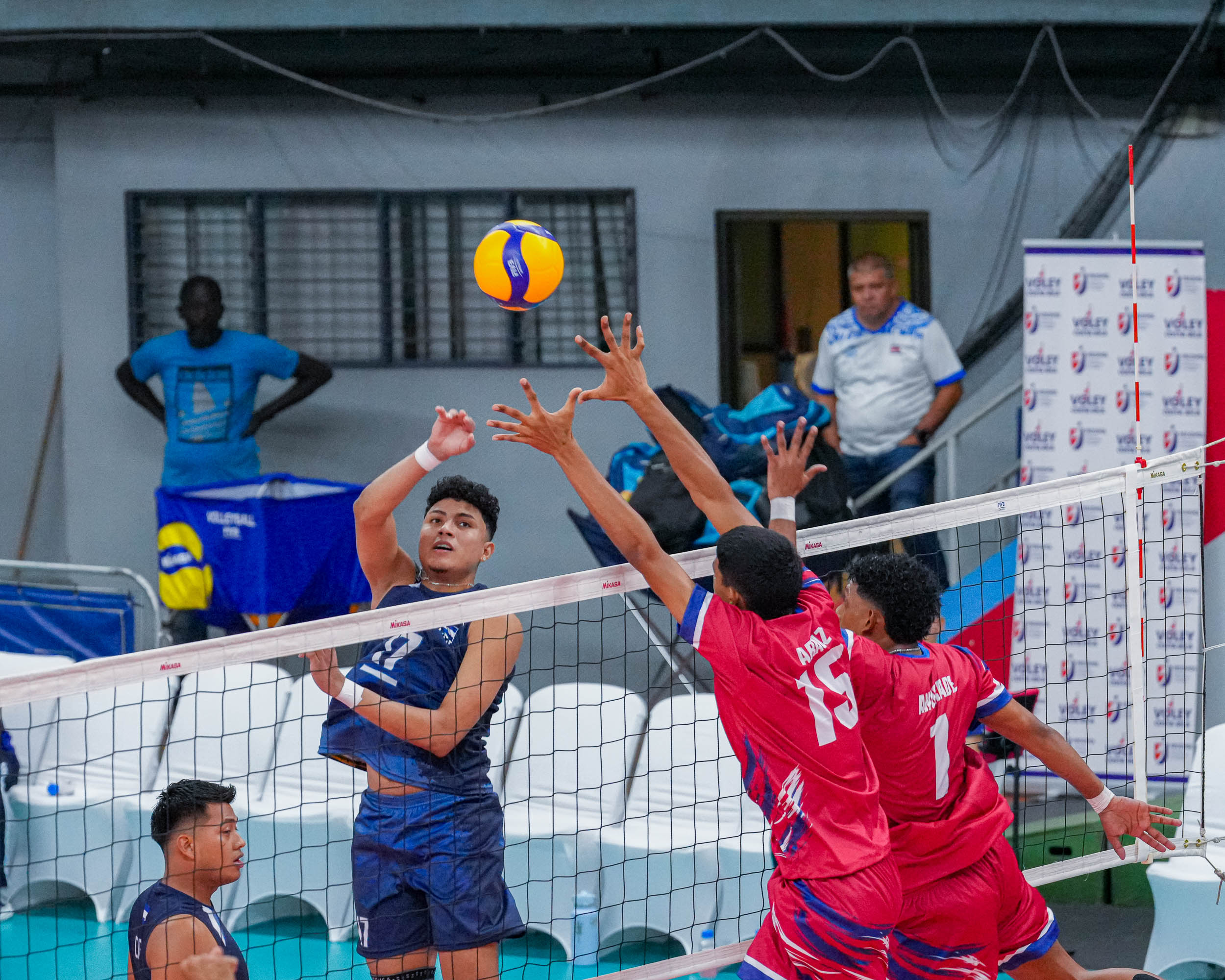 Jugador de Nicaragua remata ante el bloqueo de Panamá durante el torneo centroamericano de voleibol masculino en Costa Rica.