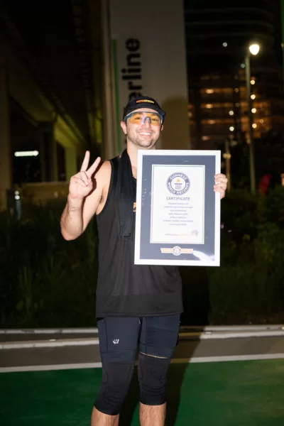 Eddy Palermo muestra el certificado de su récord Guinness tras correr mientras mezclaba música